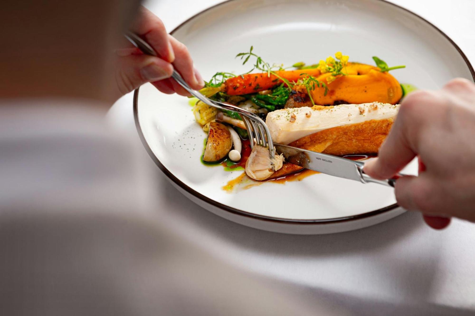 그랜드 호텔 리버 파크, 어 럭셔리 컬렉션 호텔, 브라티슬라바 외부 사진 A person using a knife and fork to cut into a meal